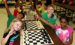 Kid Chess players posing for picture thumbs up